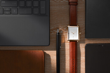 View from above of the office table with laptop, notebook, pen and wrist watch.