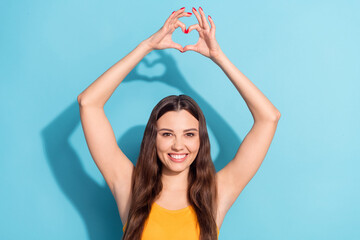 Fototapeta na wymiar Photo portrait girl demonstrating heart sign fingers smiling on date isolated pastel blue color background