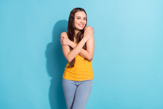 Photo portrait girl hugging herself dreamy smiling wearing casual outfit isolated pastel blue color background