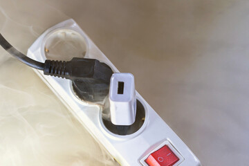 Inflamed plug in power board - result of electrical short circuit, selective focus