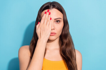 Photo portrait girl covering eye with hand checking eyesight isolated pastel blue color background...
