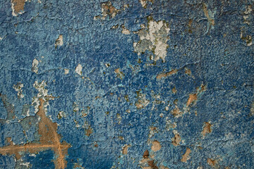 Obraz na płótnie Canvas Cracked blue paint on a concrete wall. Natural background with cracks from the time of exposure.
