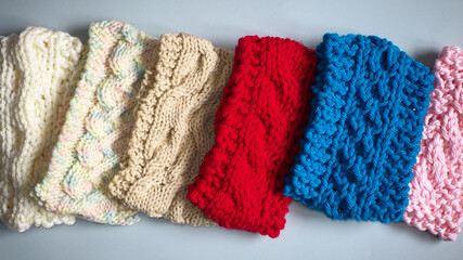 a row of hand knitted wool headbands 