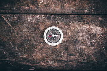 Compass on an old wooden table, terrain orientation concept, hiking