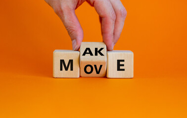 Make your move symbol. Businessman turns the wooden cube with words 'Make move'. Beautiful orange background. Make your move and business concept. Copy space.
