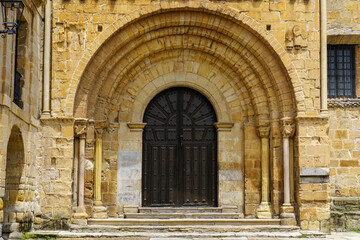 Fototapeta na wymiar Arched main door, entrance to an old Romanesque church in northern Spain. Santillana del Mar.