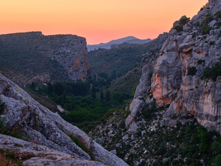 Beautiful view of a mountain landscape during sunrise. Orange sky and rocky mountains