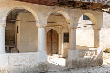 Obraz premium Ancient building with arches and ornaments made of stone wooden doors and stone benches .