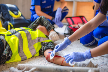 Physical injury at work of construction worker. Emergency medical teams are first aiding a...