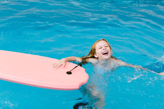 Cheerful girl playing in swimming pool
