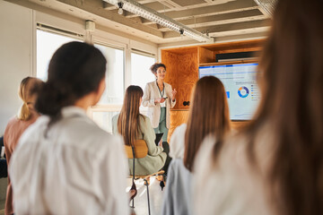 Female entrepreneur giving presentation to colleagues in conference event
