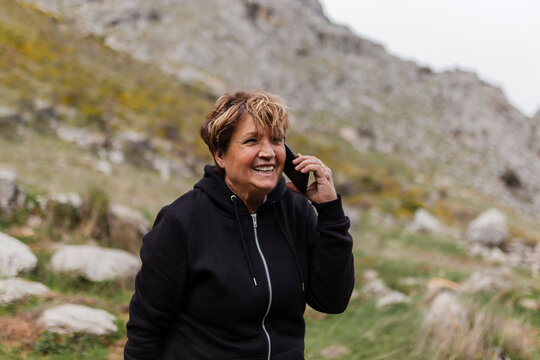 Smiling senior woman talking on mobile phone in nature