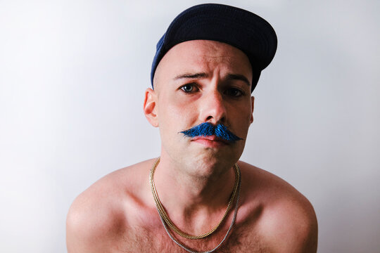 Man with mustache wearing cap against white background