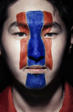 Young man with Korean flag painted on face