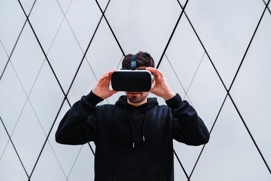 Man holding Virtual reality headset by wall