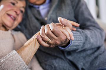 Husband and wife holding hands at home