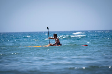 Fototapeta na wymiar Man kayaking on the beach during summer vacation