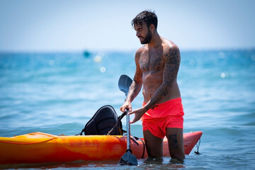 Man kayaking on the beach during summer vacation
