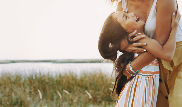 Mother embracing daughter by lake