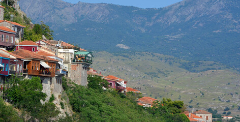 Bars and restaurants of the village of Molyvos clinging  to the hillside with backdrop of mountains. 