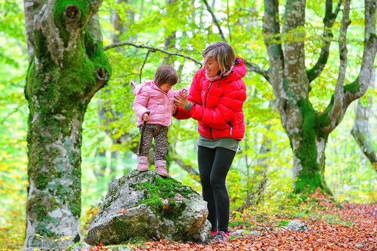 Mother holding hand of daughter standing on rock in Gorbea Natural park