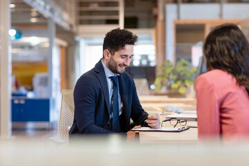Smiling businessman signing contract in coworking office