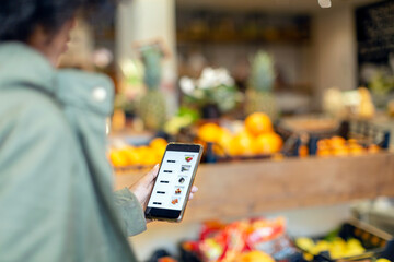 Woman buying groceries through mobile application in supermarket