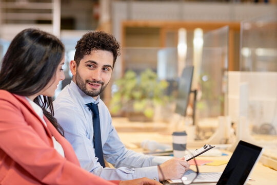 Businessman looking at female colleague working in office