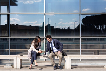 Male and female entrepreneurs discussing over digital tablet on sunny day