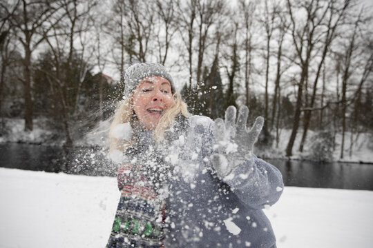 Senior woman being hit by snowball during winter