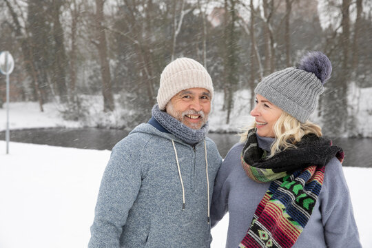 Couple smiling while standing at park during winter