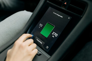 Man checking battery on screen while traveling in electric car