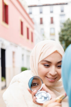 Young woman applying make-up on female friend