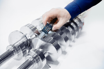 Closeup engineer checks dimensions with vernier caliper finish detail after metalworking on cnc...