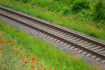 Obraz premium closeup railroad among green fields, industry transportation background