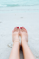 Woman walking on sand beach leaving footprint in the sand.  Beauty, health, skin care concept.