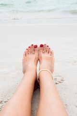 Woman walking on sand beach leaving footprint in the sand.  Beauty, health, skin care concept.