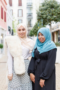 Young women wearing hijab standing on footpath