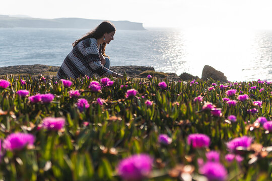 Young woman at carpobrotus edulis field by sea