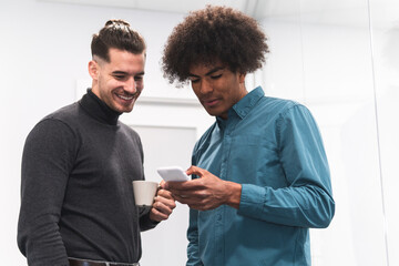 Male professionals looking at smart phone at office