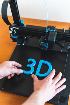Young male engineer working on 3D printer machinery