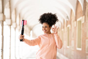 Cheerful woman gesturing while vlogging during sunny day