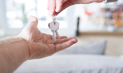 Hand handing over house keys