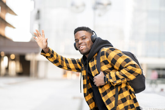 Smiling young African-American man hailing ride