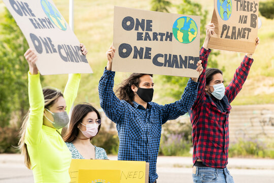 Activist holding posters on climate change on footpath