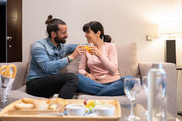 Mature couple toasting glasses at hotel suite