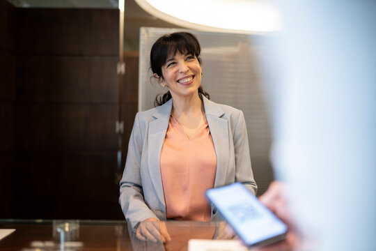 Smiling female receptionist at desk in hotel