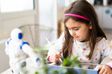 Girl using digital tablet while studying at home
