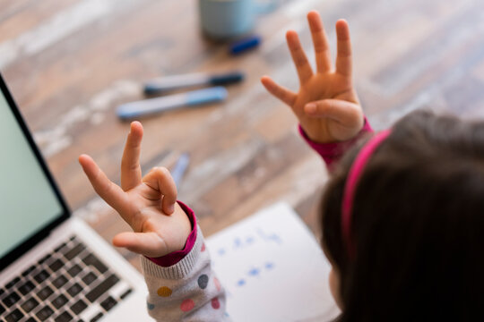 Girl counting fingers while studying at home