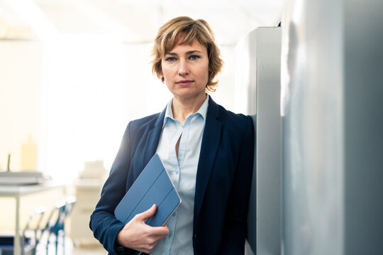 Mature manager holding digital tablet in printing factory